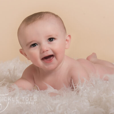 Baby lying on rug smiling baby photography in your home Dublin Kildare
