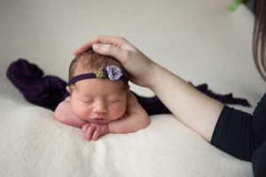 Photograph baby with head on hadnds with mum holding baby for safety. Dublin photographer Tickle Toes