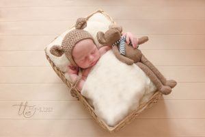 Newborn photography baby in bed with teddy